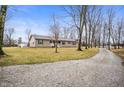 Ranch-style home featuring neutral siding, green shutters, a gravel driveway, and an American flag at 4543 E 700 N, Alexandria, IN 46001