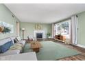 Bright living room with fireplace, large window and hardwood floors offers comfortable seating at 4905 N Dearborn St, Indianapolis, IN 46205