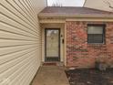 Close-up of the front door with sidelight and brick accents at 5457 Happy Hollow, Indianapolis, IN 46268