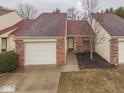 Single-story home with brick facade, attached garage, and a cozy front entrance with a tree at 5457 Happy Hollow, Indianapolis, IN 46268