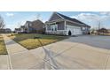 A concrete driveway leads to a two-car garage on this property with well-maintained landscaping at 5955 Stroup Dr, Noblesville, IN 46062