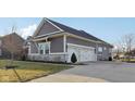 Spacious attached two car garage with white doors and gray siding offers convenient parking and storage at 5955 Stroup Dr, Noblesville, IN 46062