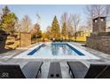 Outdoor swimming pool with lounge chairs, a brick fireplace, and privacy fence at 6640 E Deerfield Dr, Zionsville, IN 46077