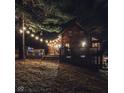 Exterior of a cozy cabin at night, featuring a large deck, and string lights at 6688 Bellsville Pike, Columbus, IN 47201