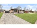 Charming brick home with concrete driveway and well-maintained landscaping at 714 S 4Th Ave, Beech Grove, IN 46107