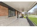 Inviting covered porch with brick accents and wrought iron railing at 714 S 4Th Ave, Beech Grove, IN 46107