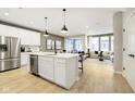 Modern kitchen with white cabinets, stainless steel appliances, and an island open to the living area at 7346 Shroyer Way, Noblesville, IN 46062