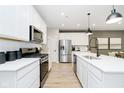 Contemporary kitchen featuring stainless steel appliances, white cabinets, and a center island with seating at 7346 Shroyer Way, Noblesville, IN 46062