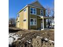 Two-story home with pale yellow and olive green siding, white trim, and a covered front porch at 922 N Oakland Ave, Indianapolis, IN 46201