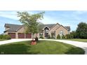 Stunning brick home featuring an expansive front yard, three-car garage and a charming circular driveway at 9615 N County Road 150 E Rd, Pittsboro, IN 46167