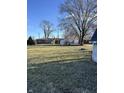 Expansive backyard featuring a well-kept lawn, mature trees, and outbuildings at 9704 Porter Dr, Avon, IN 46123