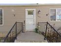 Close up of the front door with black iron railing, house number, and vinyl siding at 1019 Lennox St, Anderson, IN 46012