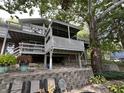 View of the home's multi-level deck and landscaping, shaded by a large tree at 1020 W Riverview Dr, Anderson, IN 46011