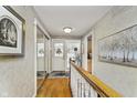 Bright hallway featuring hardwood floors and staircase leading to additional rooms at 1020 W Riverview Dr, Anderson, IN 46011