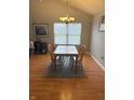 Cozy dining room featuring hardwood floors, a table with seating for four, and neutral-toned walls at 11215 Cowan Lake Ct, Indianapolis, IN 46235