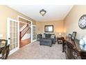Cozy living room with plush seating, elegant decor, neutral walls, and a view to the staircase at 14034 Wicklow Ln, Fishers, IN 46040