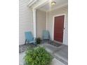Inviting front porch with neutral siding, red door, and seating, creating a welcoming entrance at 14309 Shooting Star Dr, Noblesville, IN 46060