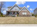 Charming two-story home with a brick facade, inviting front porch and beautifully landscaped yard at 17136 Wetherington Dr, Westfield, IN 46074