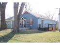 Cozy blue home with black railings, complemented by lush green lawn, offers a warm and welcoming curb appeal at 2908 N Colorado Ave, Indianapolis, IN 46218