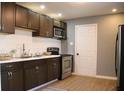 Modern kitchen featuring sleek dark cabinets, stainless steel appliances, and stylish subway tile backsplash at 2908 N Colorado Ave, Indianapolis, IN 46218