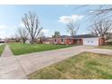 Charming brick home with a well-maintained lawn and a spacious driveway at 3125 Anniston Dr, Indianapolis, IN 46227