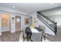 Bright dining area features gray walls, modern furnishings, and a staircase with black railings at 3406 E 20Th St, Indianapolis, IN 46218