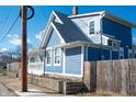 Side view of a charming blue house featuring white trim, a covered porch, and a well-kept yard at 3406 E 20Th St, Indianapolis, IN 46218
