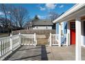 Exterior deck with white railing leads to a charming home with a red door at 3406 E 20Th St, Indianapolis, IN 46218