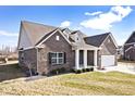 Beautiful brick home with dormers, manicured lawn, and covered porch with white columns at 3532 Danbury Ct, Bargersville, IN 46106