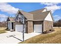 Side view of a brick home with a driveway and a basketball hoop above the two car garage at 3532 Danbury Ct, Bargersville, IN 46106