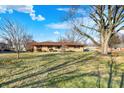 Spacious lawn featuring a single story home with mature trees on a sunny day at 358 Webb Dr, Indianapolis, IN 46227