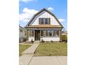 Inviting two-story home boasts a classic design, complemented by a lush green lawn and beautiful landscaping at 360 S Spencer Ave, Indianapolis, IN 46219