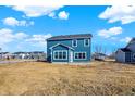 Rear view of a two-story blue home, showcasing the backyard space and neighborhood at 3667 Thomas Jefferson St, Westfield, IN 46074