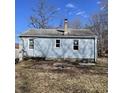 View of the back of the home, showing the light blue siding and a chimney on the roof at 3748 N Olney St, Indianapolis, IN 46218