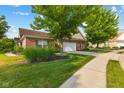 This single-story brick home has an attached garage, mature trees, and a well-manicured lawn for beautiful curb appeal at 5115 Baltustrol Dr, Avon, IN 46123