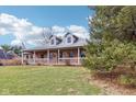 Traditional brick home showcasing a covered front porch and well-maintained lawn and mature landscaping at 520 Denny Dr, Mooresville, IN 46158