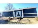 Rear exterior view with fresh landscaping and a set of double doors leading to a small deck at 6130 E 169Th St, Noblesville, IN 46062
