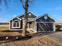 A gray home with an attached garage, neat landscaping, and a well-manicured front yard at 6130 E 169Th St, Noblesville, IN 46062