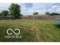 Fenced backyard with mature trees, offering privacy and space for outdoor activities at 6721 Jackson St, Anderson, IN 46013