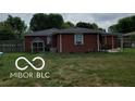 Spacious backyard showcasing the home's exterior with a covered patio at 6721 Jackson St, Anderson, IN 46013