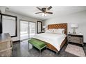 Comfortable main bedroom featuring a tufted headboard, stylish furniture, and access to outdoor space at 7143 W 50 S, Morgantown, IN 46160