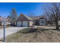 Attractive brick home with manicured front lawn, two-car garage and established trees at 7195 Koldyke Dr, Fishers, IN 46038