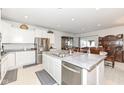 Bright kitchen featuring white cabinets, stainless steel appliances, a large island, and an adjacent dining area at 936 Plunkett Ave, Westfield, IN 46074