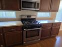Kitchen featuring stainless steel appliances, dark cabinets, and stone countertops at 9808 Worthington Blvd, Fishers, IN 46038