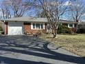 Red brick ranch-style home with attached garage and long asphalt driveway at 1031 Schleicher Ave, Indianapolis, IN 46229