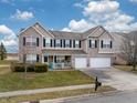 Attractive two-story home featuring a covered front porch, brick and siding, plus a two-car garage at 10535 Pokagon Way, Indianapolis, IN 46239