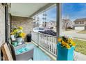 Inviting front porch with cozy seating and colorful potted flowers, perfect for relaxation at 10535 Pokagon Way, Indianapolis, IN 46239