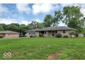 View of the home, featuring the front lawn, stone facade and attached garage at 120 E Beechwood Ln, Indianapolis, IN 46227