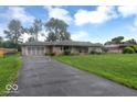View of the home featuring a driveway, attached garage and well-maintained lawn at 120 E Beechwood Ln, Indianapolis, IN 46227