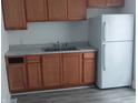 Standard kitchen with basic wood cabinets and white refrigerator at 1311 N Olney St, Indianapolis, IN 46201